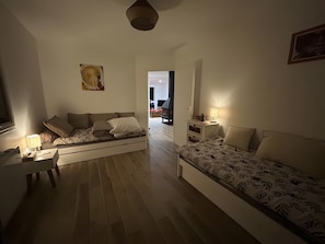 Une chambre moderne avec un canapé, un bureau, une lampe et un tableau au mur.
