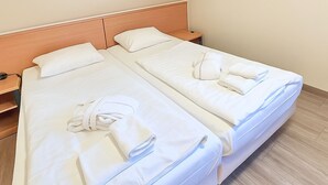 A hotel room with two single beds, each with white linens and towels. - Classic apartment with 1 bedroom and balcony on the top floor (Ostseebad Binz)