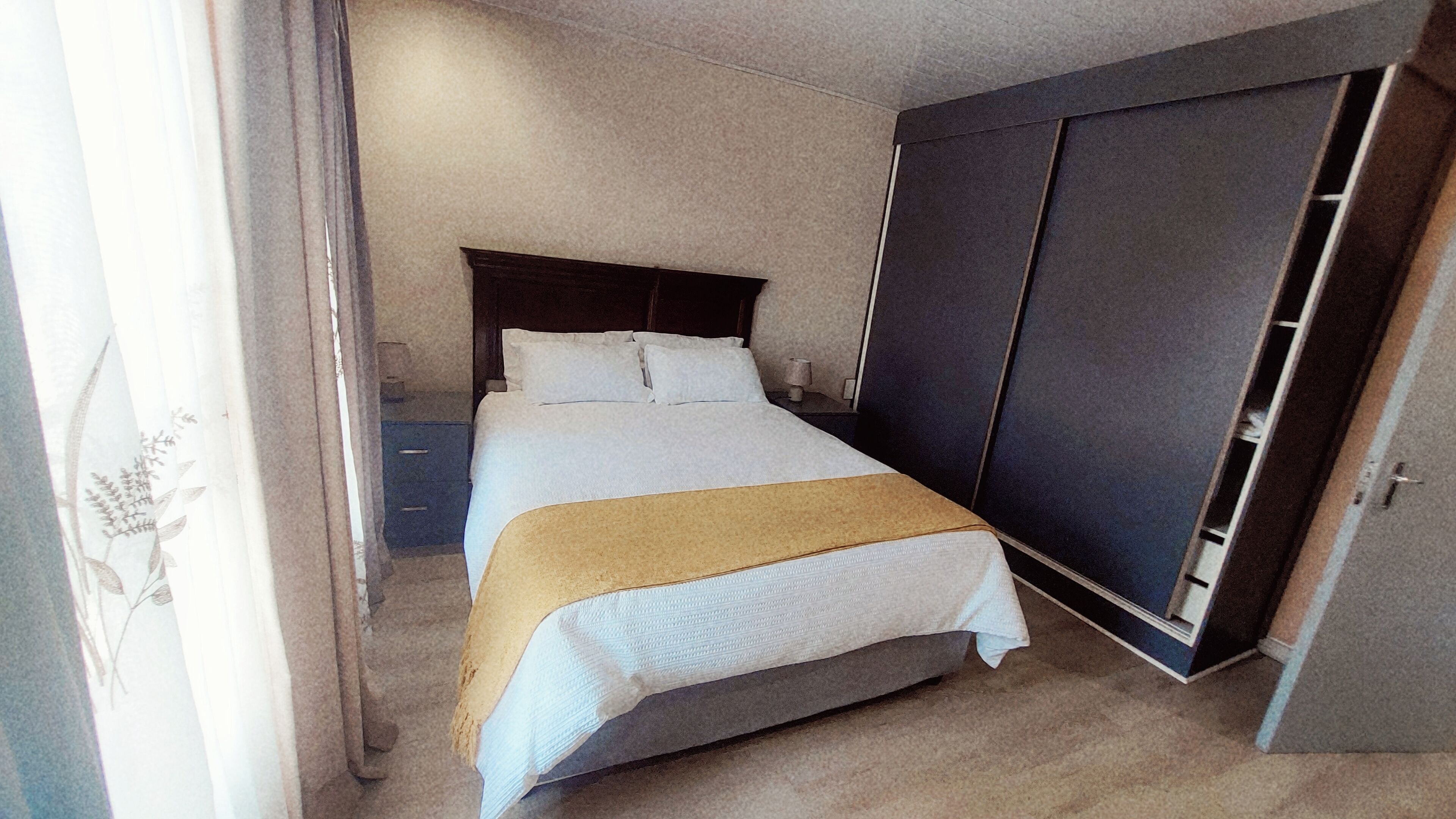Ein Schlafzimmer mit einem Bett, einem Kleiderschrank und einem Nachttisch.
