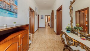 Ein Flur mit einem Holzschrank, einem großen Spiegel und einem Stadtbild.