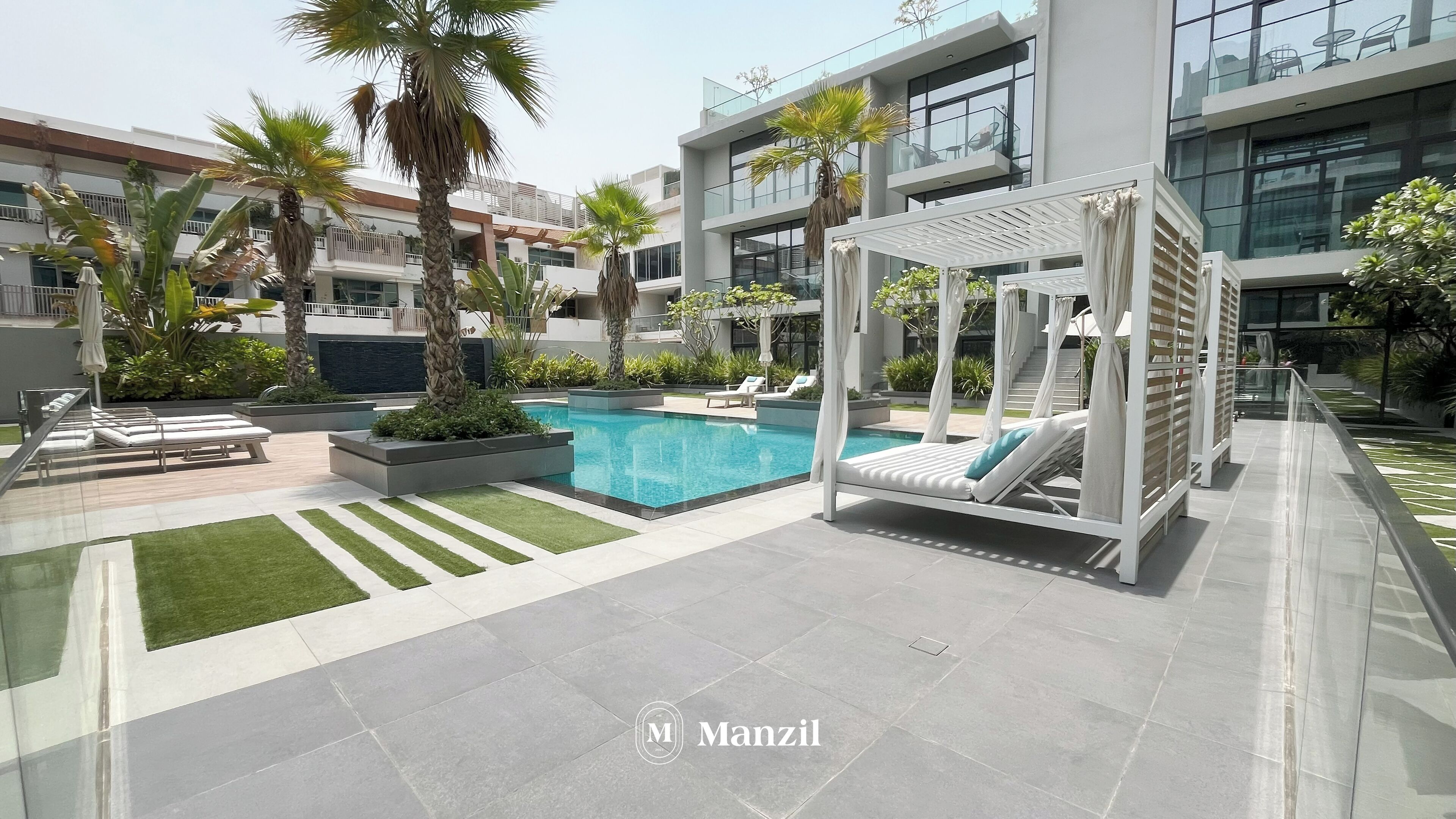 A modern outdoor pool area with lounge chairs, a pergola, and a clear blue pool.