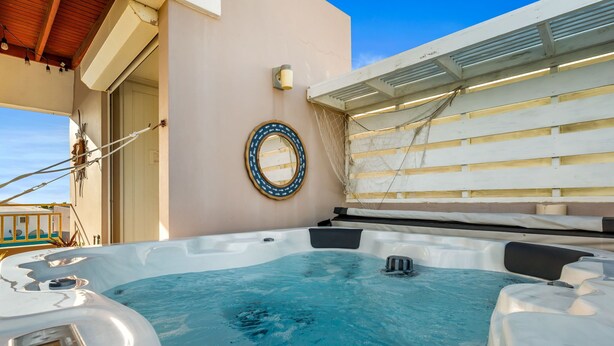 A hot tub with a control panel, a circular light fixture, and a netted enclosure. - Tropical Sunset Penthouse • Rooftop & Hot Tub (Cabo Rojo)