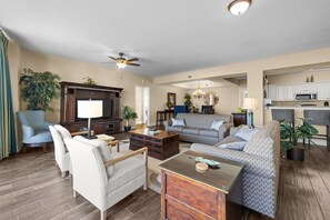 A spacious living room with a television, sofas, and a coffee table. - Oceanfront 5 Bdrm 17th Flr Beach or Golf Outings (North Myrtle Beach)