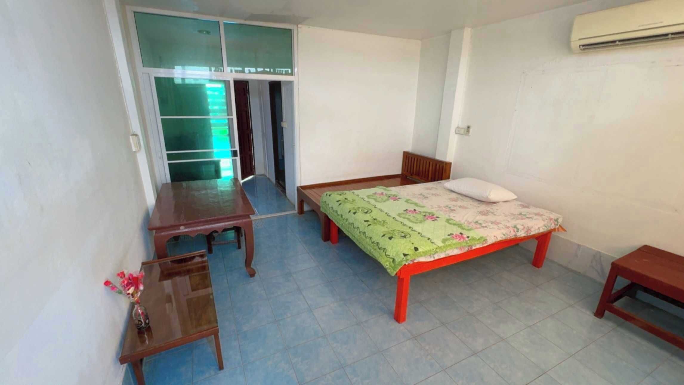 Una habitación con una cama, un escritorio, una silla y una mesita.