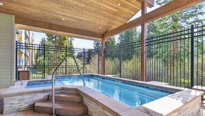 An outdoor swimming pool with a stone border, steps leading into the water, and a metal fence surrounding the area. - Best in Breck. Ski in, ski out. Pool and hot tubs. (Breckenridge)