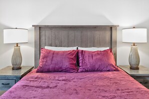 A bed with a wooden headboard, two bedside lamps, and two pillows. - Best in Breck. Ski in, ski out. Pool and hot tubs. (Breckenridge)