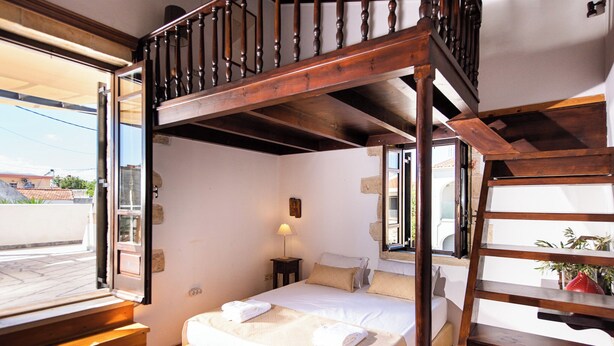 A bedroom with a wooden bunk bed, a small bedside table with a lamp, and a view of the outside. - Tzivaeri, Lovely village house with ample outdoor area and plunge pool. (Chania)