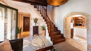 A staircase with wooden railings and a large pendant light, leading to a stone archway. - Tzivaeri, Lovely village house with ample outdoor area and plunge pool. (Chania)