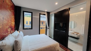 A modern hotel room with a large bed, a TV, a bathroom with a sink and mirror, and a view of the outside balcony. - Lynntimes Thanh Thuy Wellness Resort (Thanh Thuy)