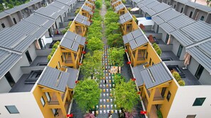 A symmetrical residential building with a central courtyard, featuring uniform balconies and a central walkway. - Lynntimes Thanh Thuy Wellness Resort (Thanh Thuy)