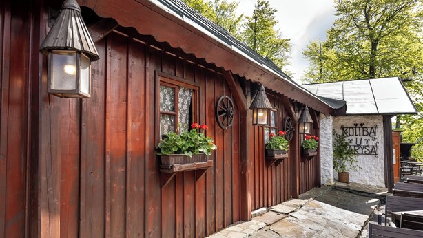 A wooden building with a stone pathway leading to outdoor seating. - Hotel Tanečnica (Prostredni Becva)