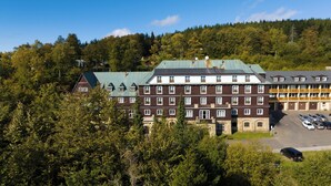 A multi-story hotel with a traditional architectural style, featuring a central courtyard and a parking area. - Hotel Tanečnica (Prostredni Becva)