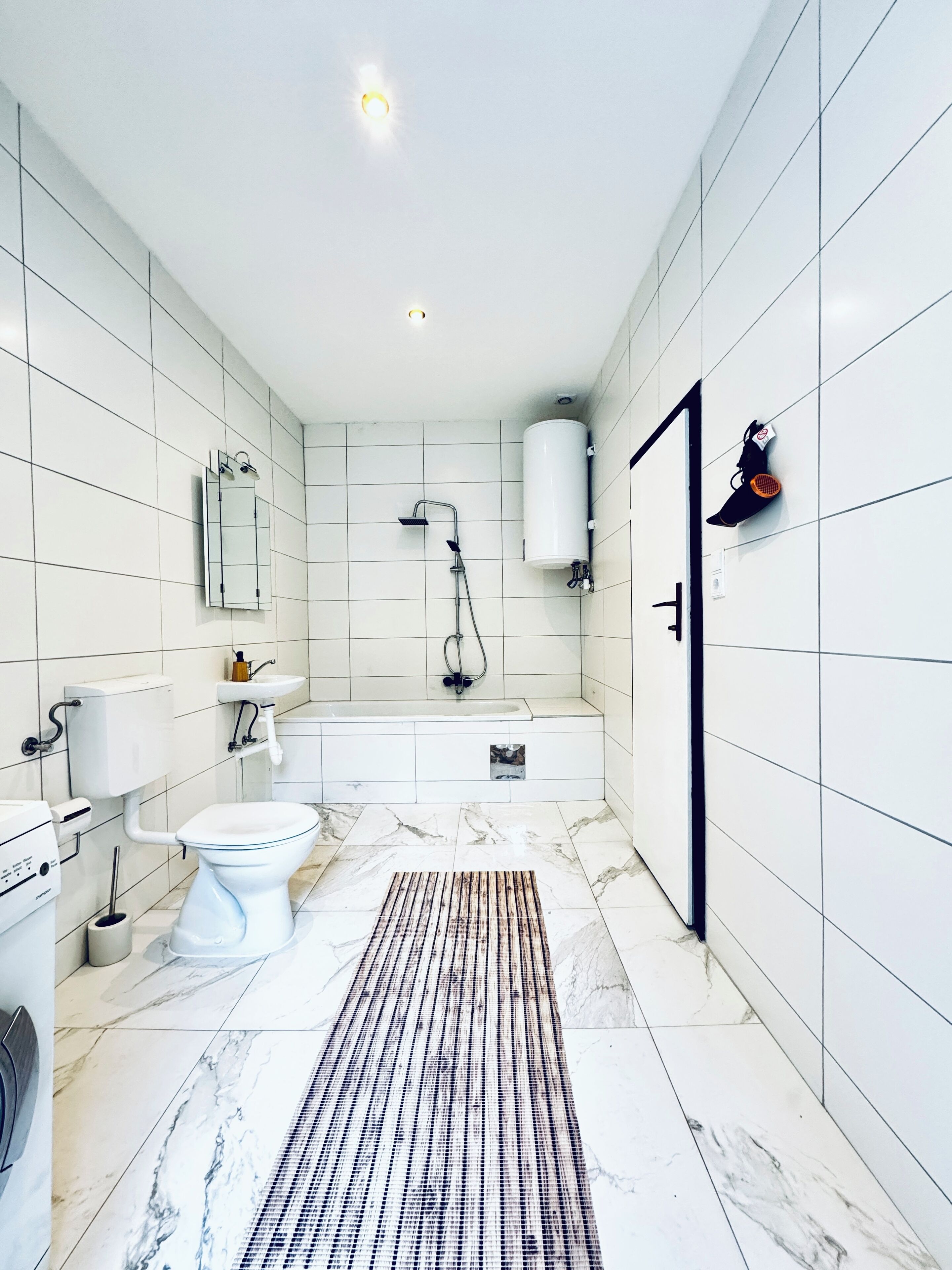 A modern bathroom with a toilet, sink, and shower.