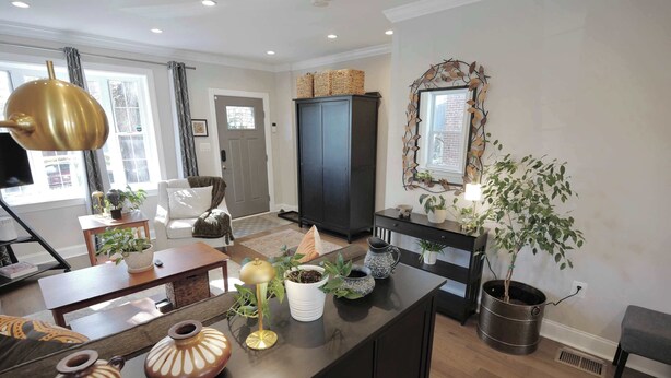 A living room with a sofa, a coffee table, a cabinet, and a potted plant. - The Brightwood House - Family Living in the Heart of DC! (Washington)