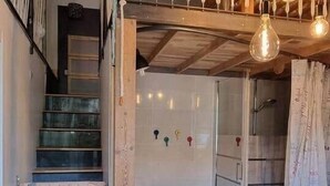 A wooden staircase leading to a loft bedroom with a glass shower and a small bathroom. - L'atelier du Centre D'ax les Thermes (Ax-les-Thermes)