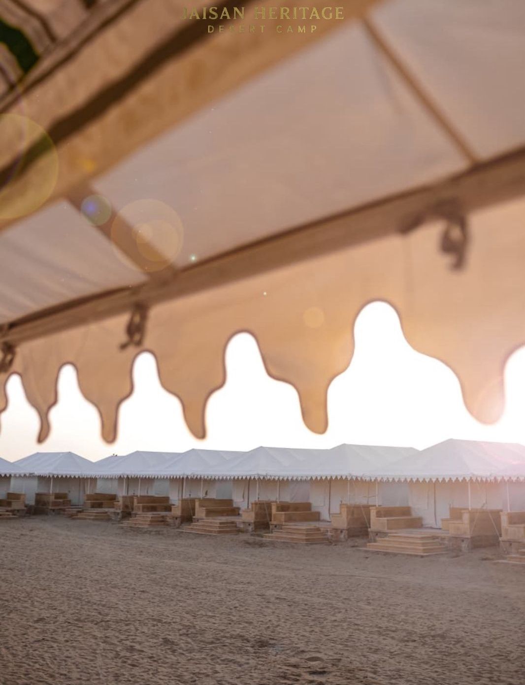 A desert camp with tents and wooden structures.