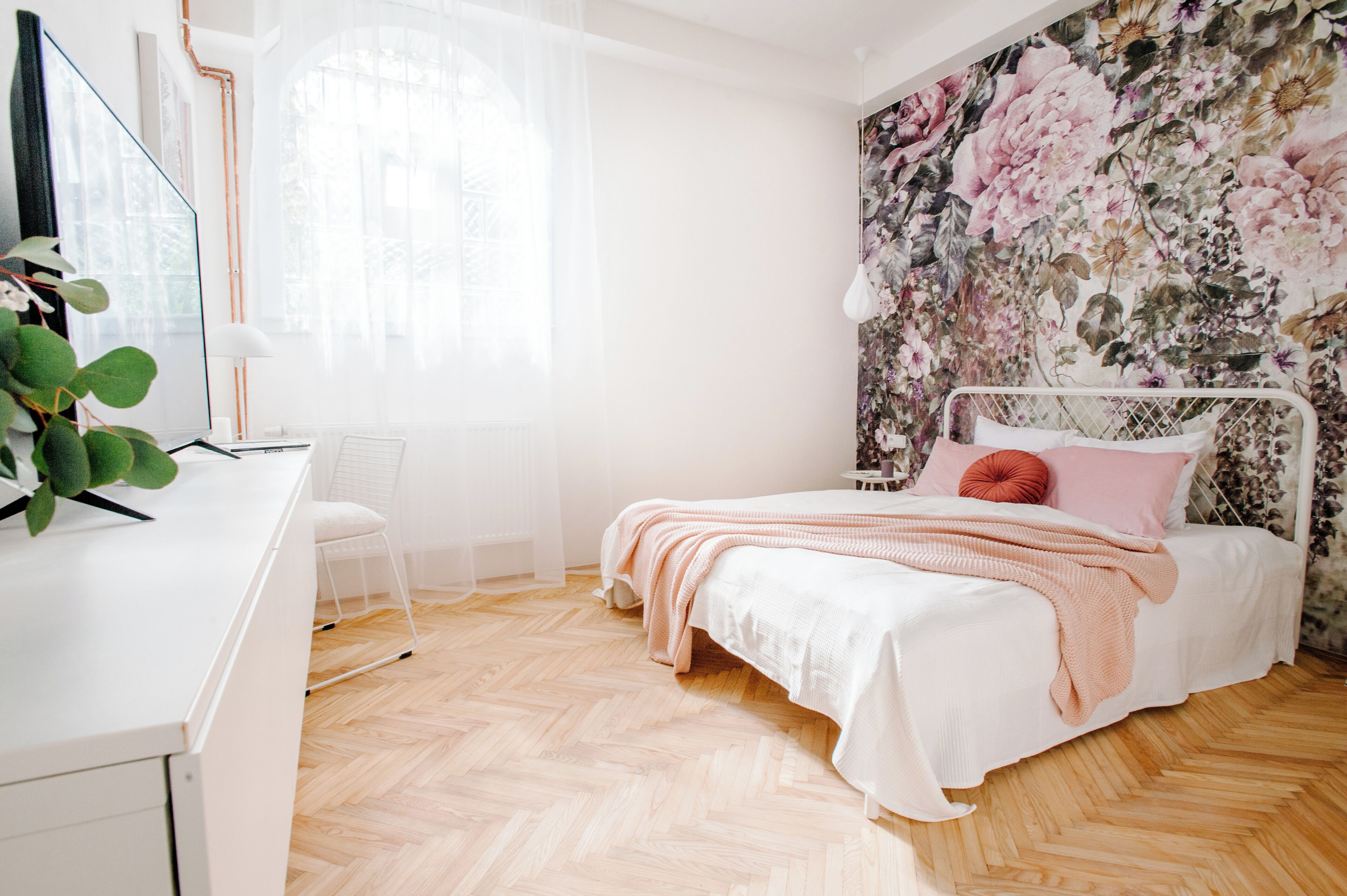 A bedroom with a bed, a desk, and a chair.