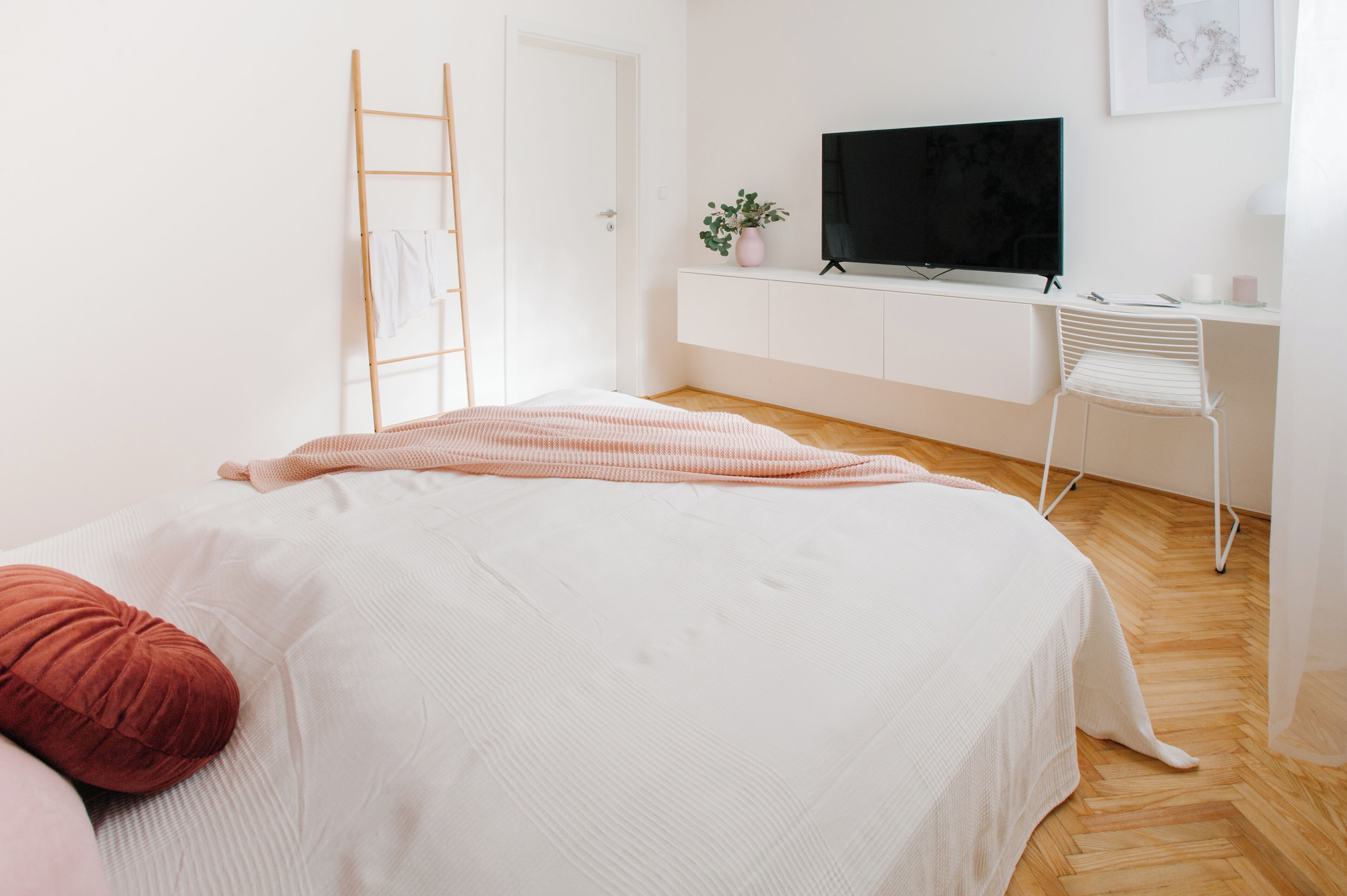 Ein Schlafzimmer mit Bett, Fernseher, Schreibtisch und Stuhl.