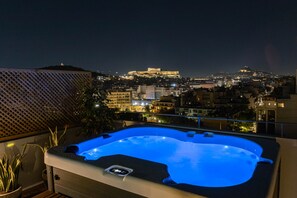 A hot tub on a balcony with a cityscape view, including a prominent hilltop structure. - Acropolis Sky Retreat | Jacuzzi & 3BR Maisonette (Athens)