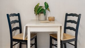Une table à manger avec deux chaises, une plante en pot et une petite boîte en bois posée sur la table.