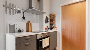 Une cuisine équipée d’une cuisinière, d’un four et de divers ustensiles.