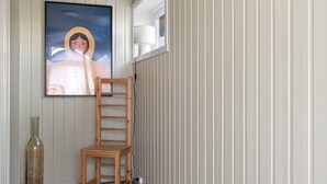 En gang med en træstol, et indrammet kunstværk og en radiator.