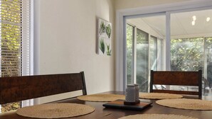 A dining table with four woven placemats, two wooden chairs, and a salt and pepper shaker on a black tray. - CozyCottage_Sleeps8_Near Plaza and KU_and Shopping (Mission)