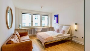 Une chambre à coucher avec un lit, un bureau, une chaise, un radiateur et une fenêtre.