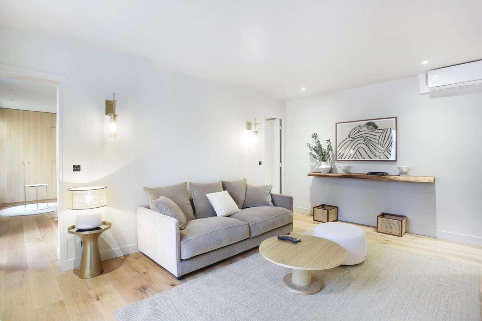 A modern living room with a grey sofa, a round coffee table, and a minimalist design.