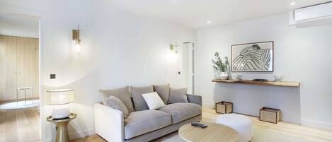 A modern living room with a grey sofa, a round coffee table, and a minimalist design.