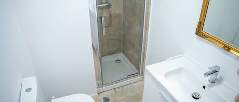 Ein Badezimmer mit Dusche, Toilette und Waschbecken.