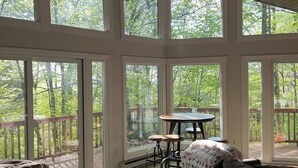 A spacious room with large windows, a wooden ceiling, and a cozy seating area with a couch and a table. - Fabulous 3-bedroom chalet in Hidden Valley, PA; walk to the slopes! (Hidden Valley)