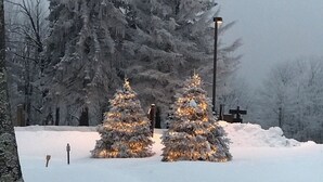 A snowy landscape with two illuminated Christmas trees and a cross in the background. - Fabulous 3-bedroom chalet in Hidden Valley, PA; walk to the slopes! (Hidden Valley)