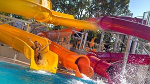 Um parque aquático com vários toboáguas e uma piscina.