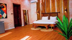Un dormitorio con una cama de madera, un cuadro grande y una planta en maceta.