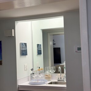 A bathroom with a large mirror, a sink, and a window. - 15% off weekly stays thru Aug. (Sat to Sat) 3BDR 2.5 BA OCEANVIEW condo. (North Myrtle Beach)
