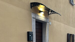 En byggnads entré med en trädörr, en liten trappa och en brevlåda.