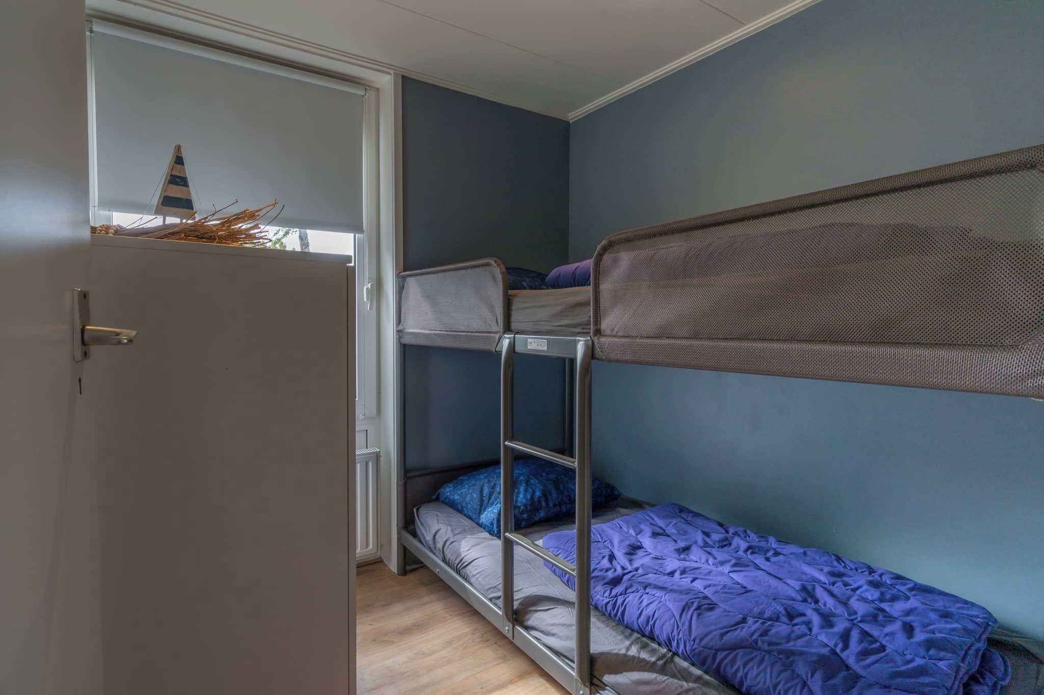 A bunk bed room with a window and a door.