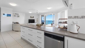 Una cocina moderna con lavavajillas, cafetera y vistas al exterior.