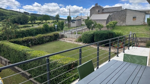 A rural landscape with stone buildings, a fenced garden, and a clear sky. - Holiday Home "La Maison De Campagne" with Mountain View, Private Terrace and Garden (Salles-Curan)