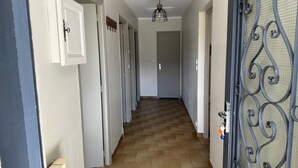 A hallway with doors on both sides, a patterned floor, and a metal gate on the right. - Holiday Home "La Maison De Campagne" with Mountain View, Private Terrace and Garden (Salles-Curan)