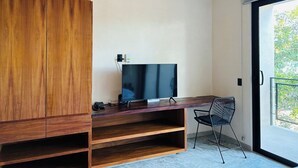 Ett modernt kontorsutrymme med ett skrivbord i trä, en platt-TV, en telefon och en stol.