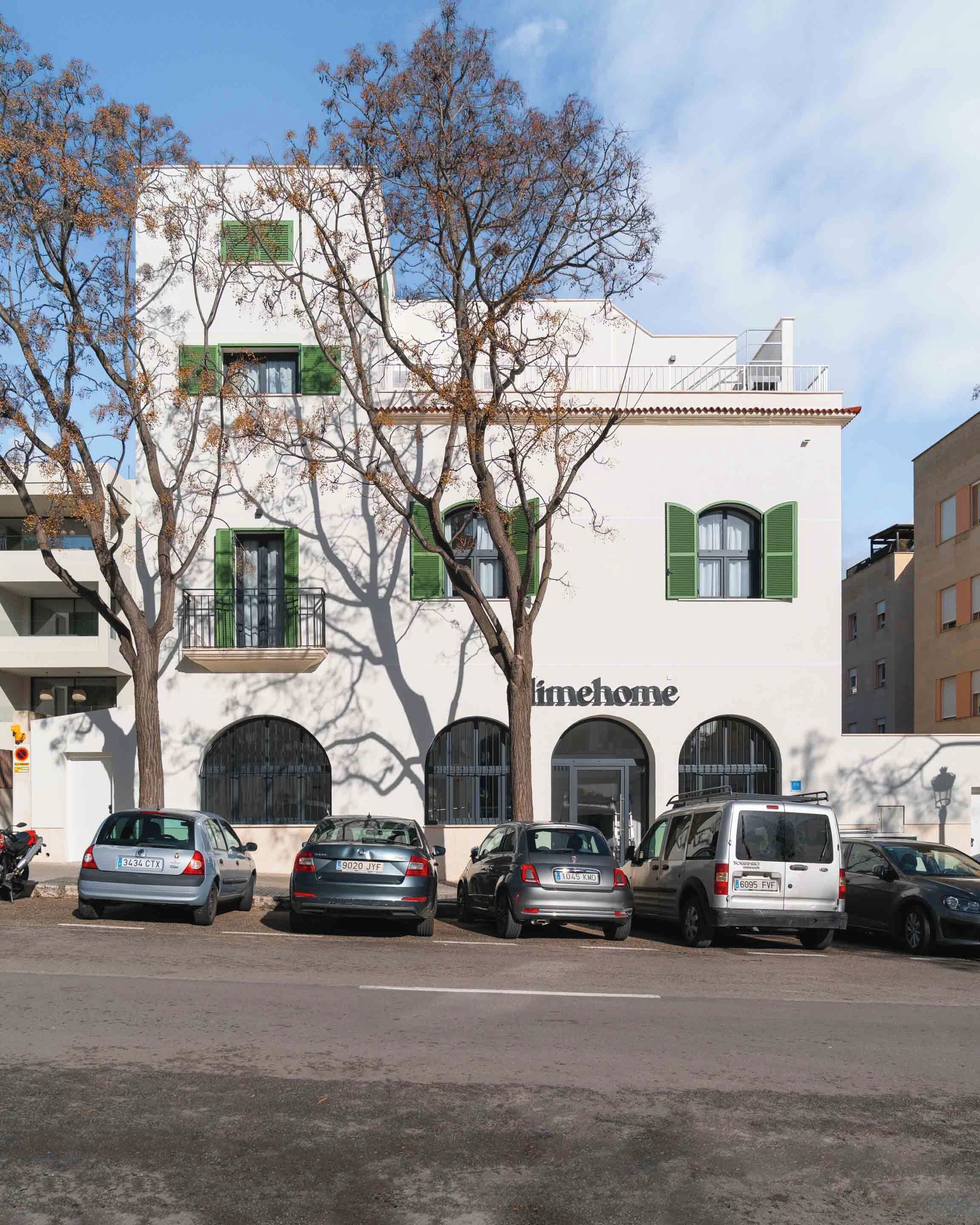 A building with a white facade, green shutters, and a sign reading "timehome".