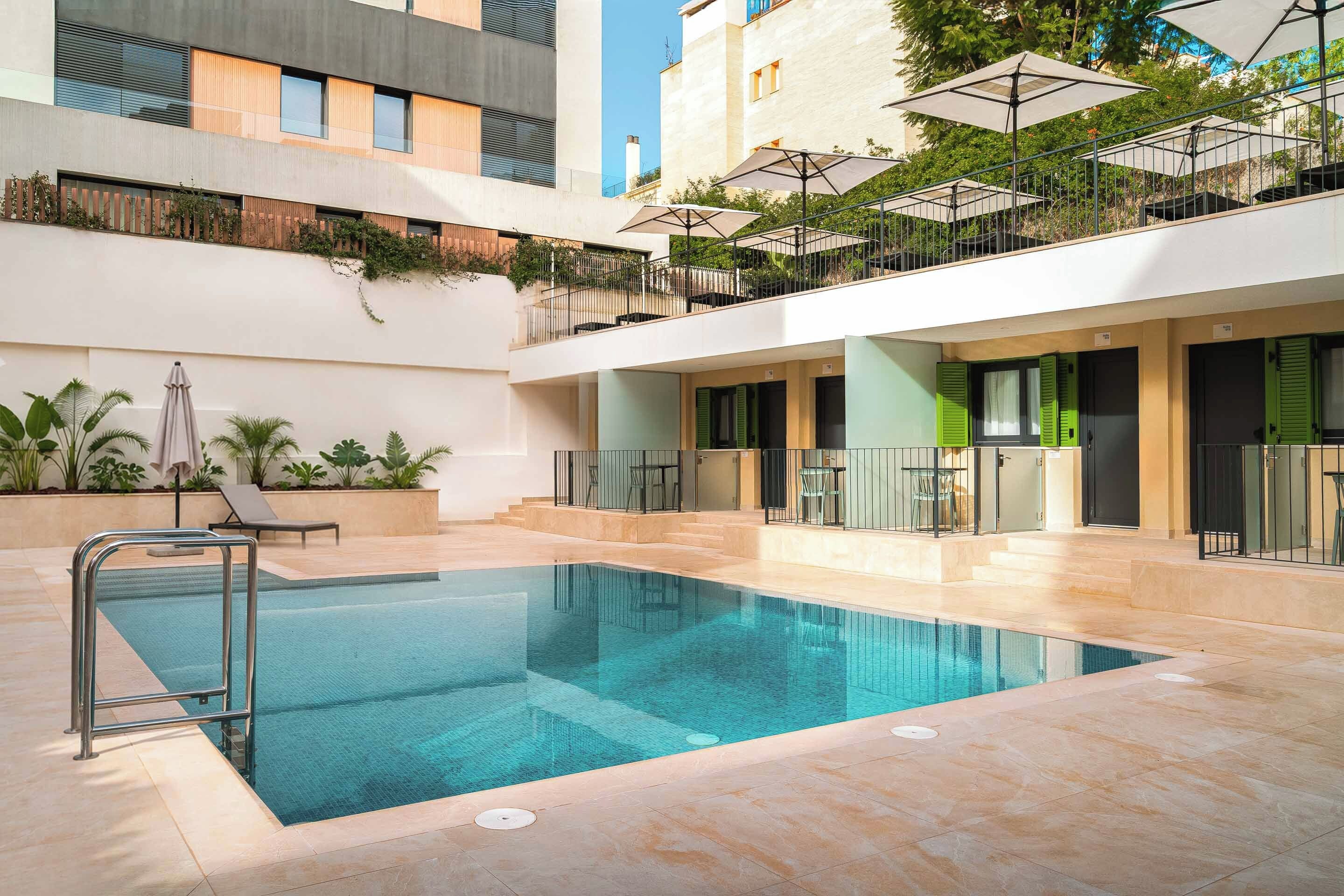 A swimming pool with a metal safety barrier, surrounded by a tiled deck.