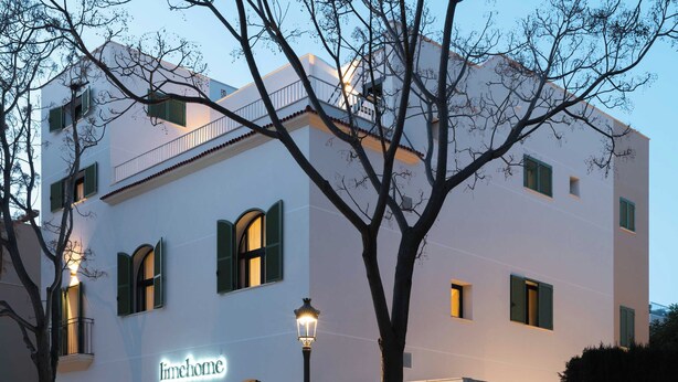 Un edificio con ventanas de arco y un balcón, identificado como "limehome".