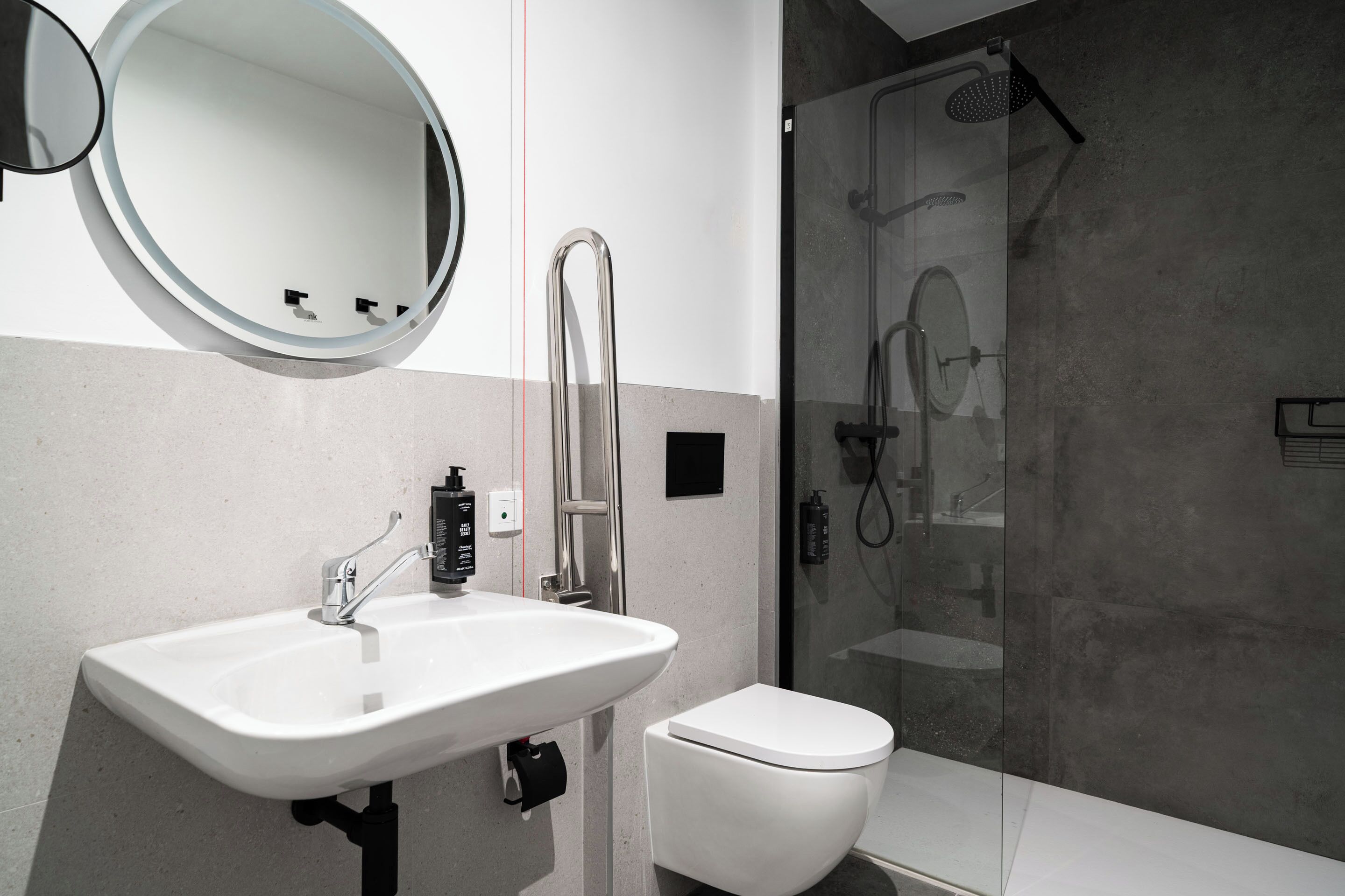 Un baño moderno con lavamanos, inodoro y cabina de ducha de vidrio.