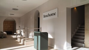 Un interior moderno con una escalera, un mostrador de recepción y un cartel que dice 'limehome'.