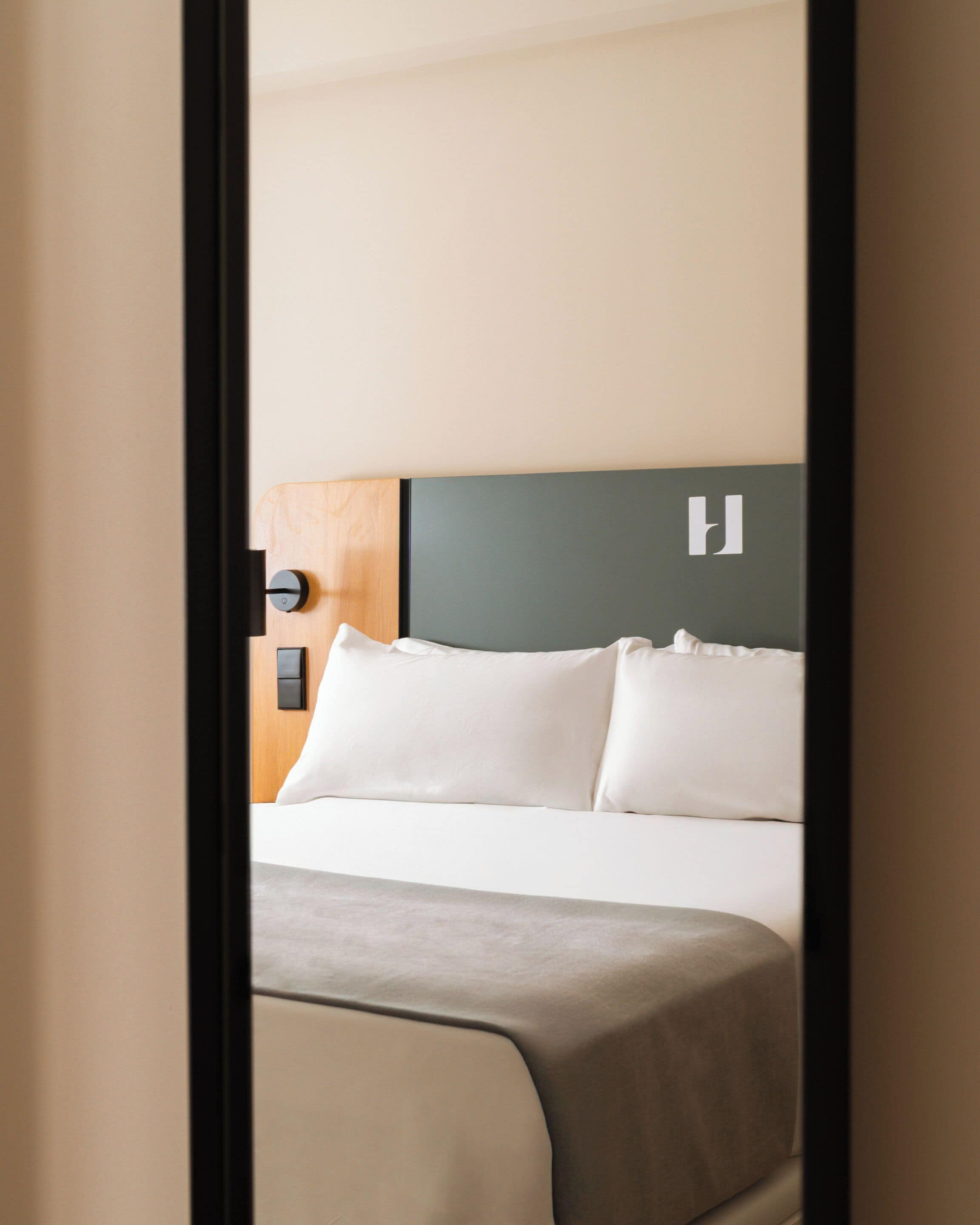 A hotel room with a bed, a headboard, and a nightstand.