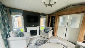A spacious living room with a fireplace, two sofas, a television, and a large window. - Host Stay Coopers Corner (York)