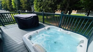 A hot tub on a wooden deck with a metal railing, surrounded by trees. - Host Stay Coopers Corner (York)